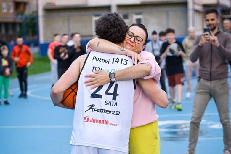 A person hugging a person on a basketball courtAI-generated content may be incorrect.