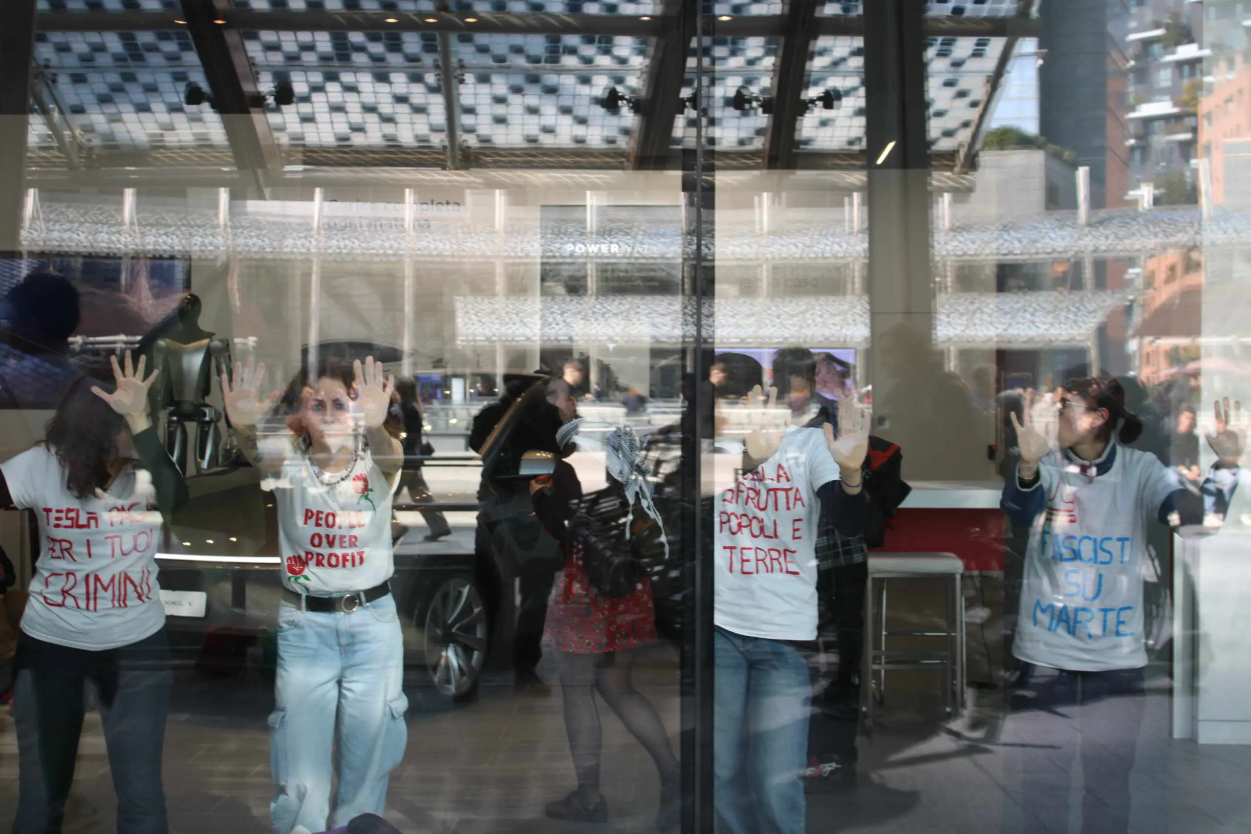 Attivisti bloccano le vetrine del negozio Tesla a Milano